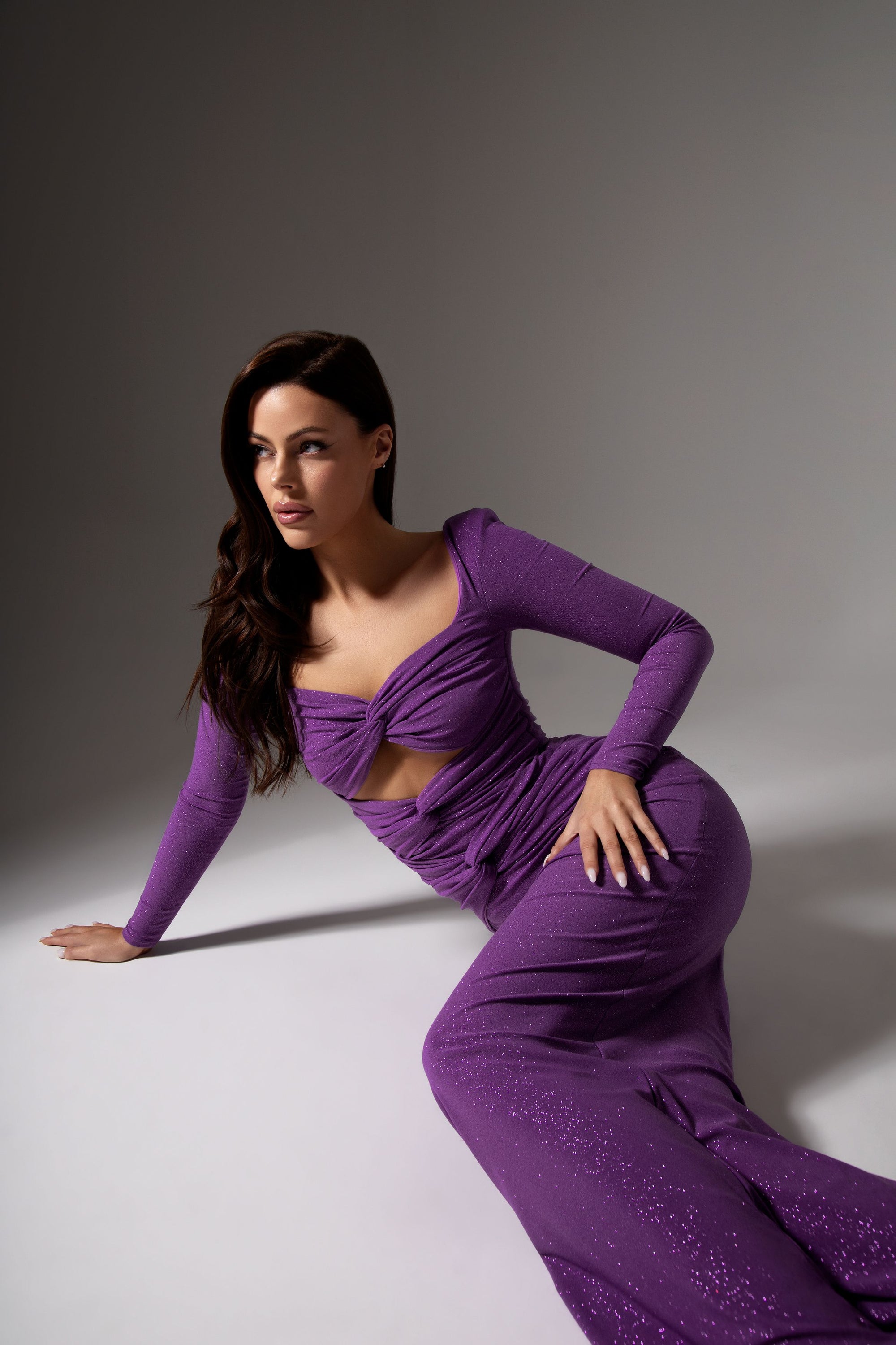 Langes, violettes Glitzerkleid mit enganliegender Silhouette, Cut-out-Details und drapiertem Oberteil.