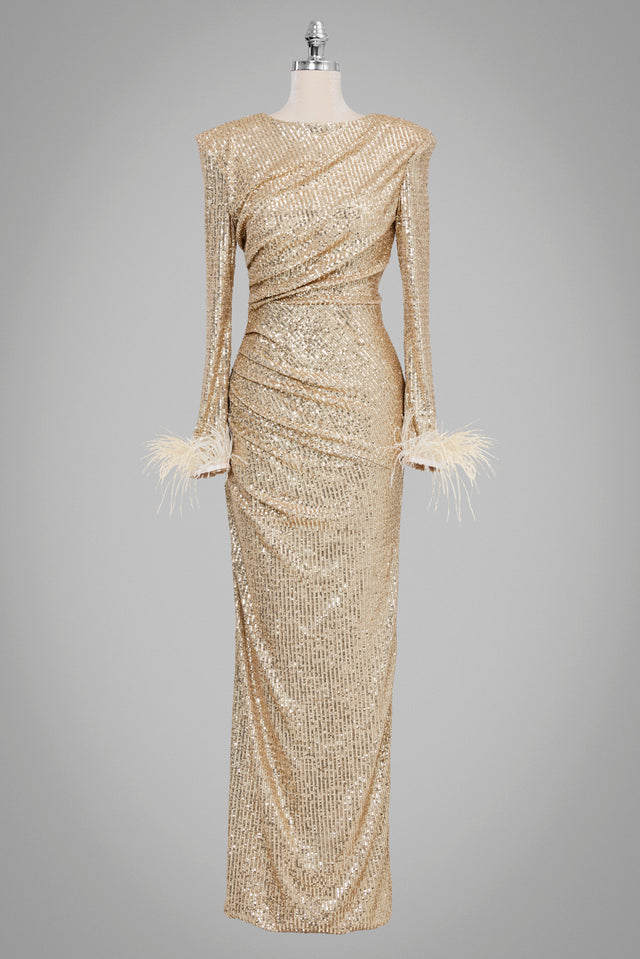 Langes, goldiges Paillettenkleid mit langen Ärmeln, Federn an den Bündchen und figurbetonter Silhouette.