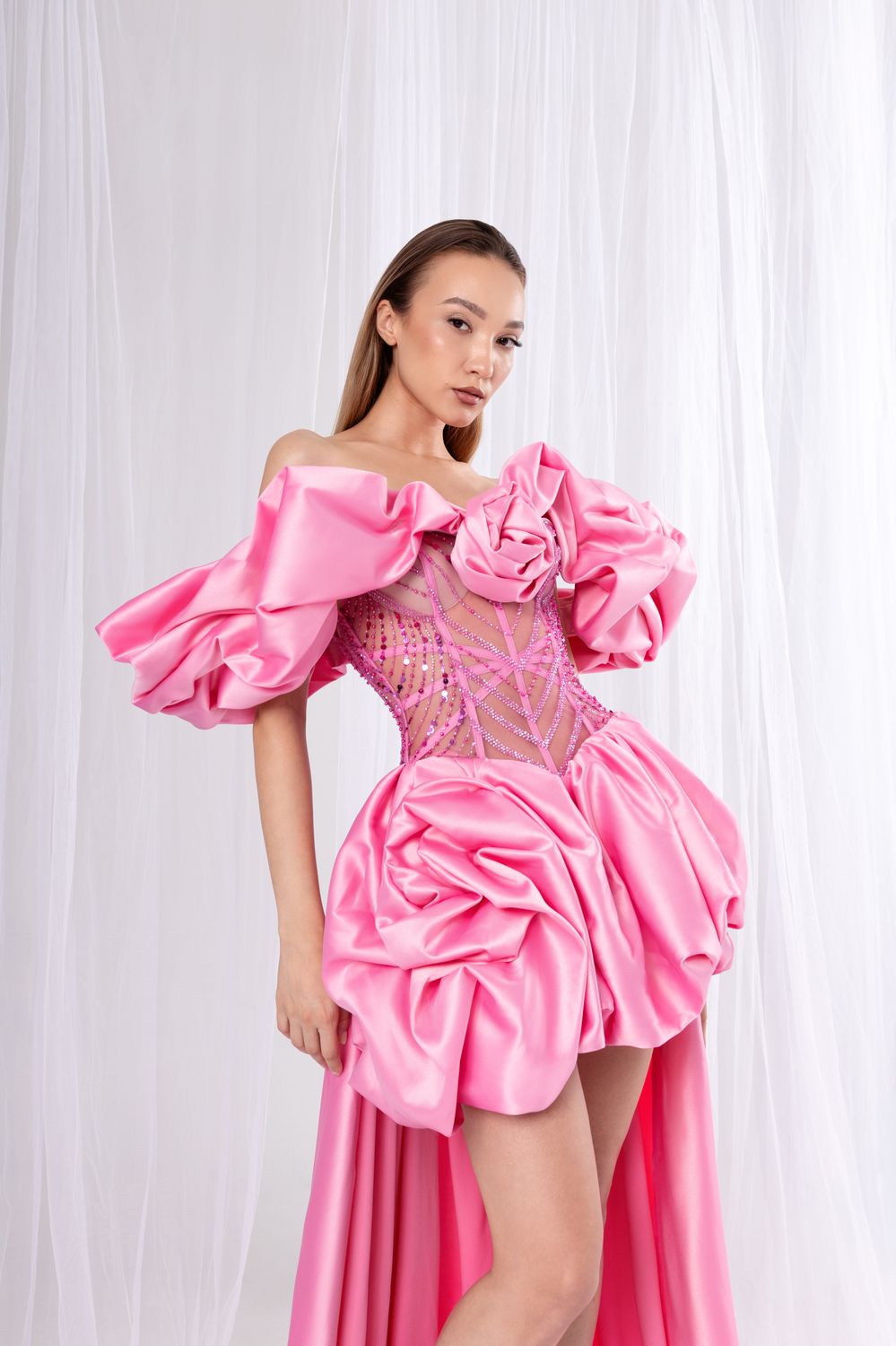 Opulentes, schulterfreies Kleid in Rosa mit voluminösen Rüschenärmeln, Korsett und drapiertem Rock mit Schleppe.
